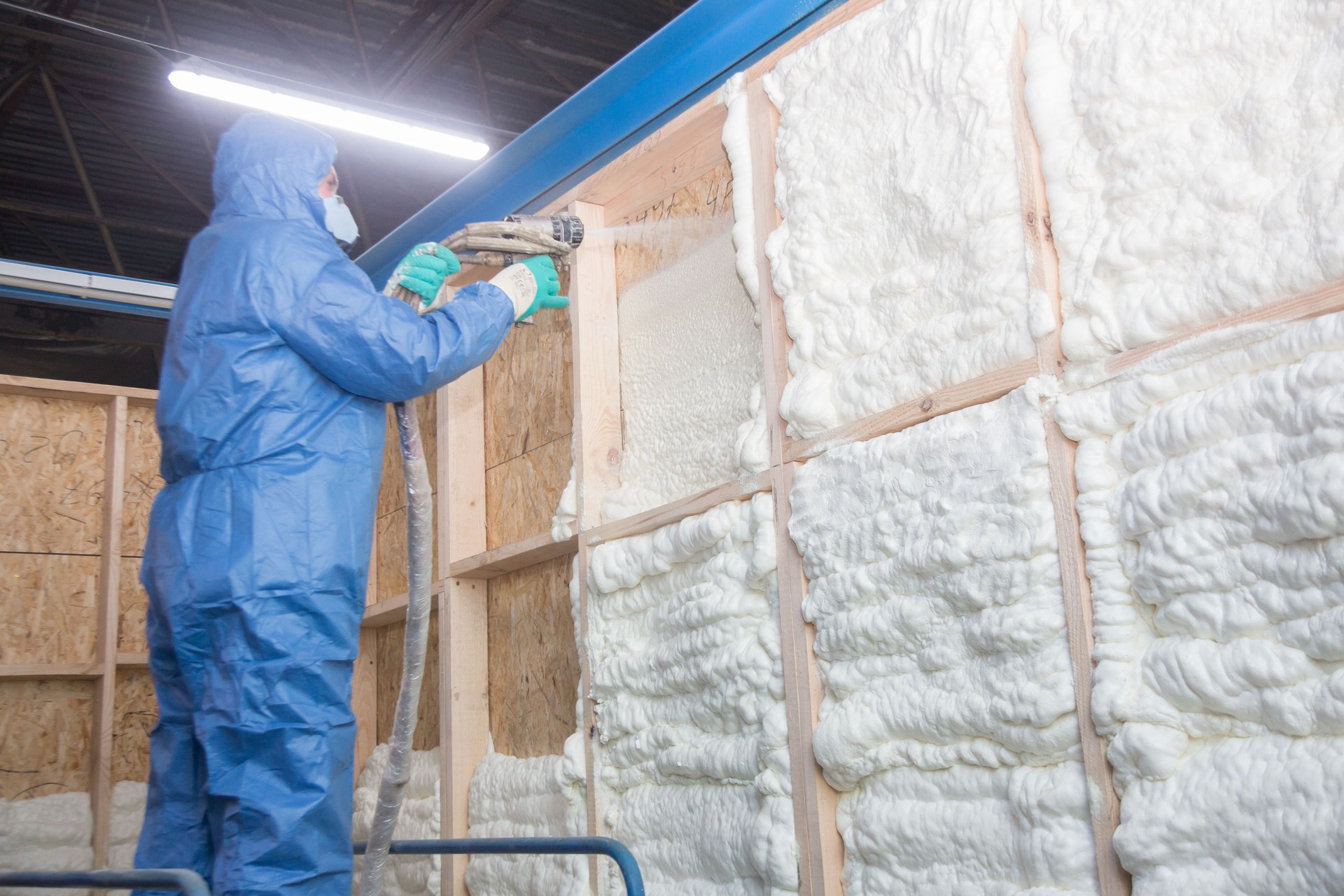 Insulation of walls with foam, energy and heat saving of walls, worker treats walls with foam